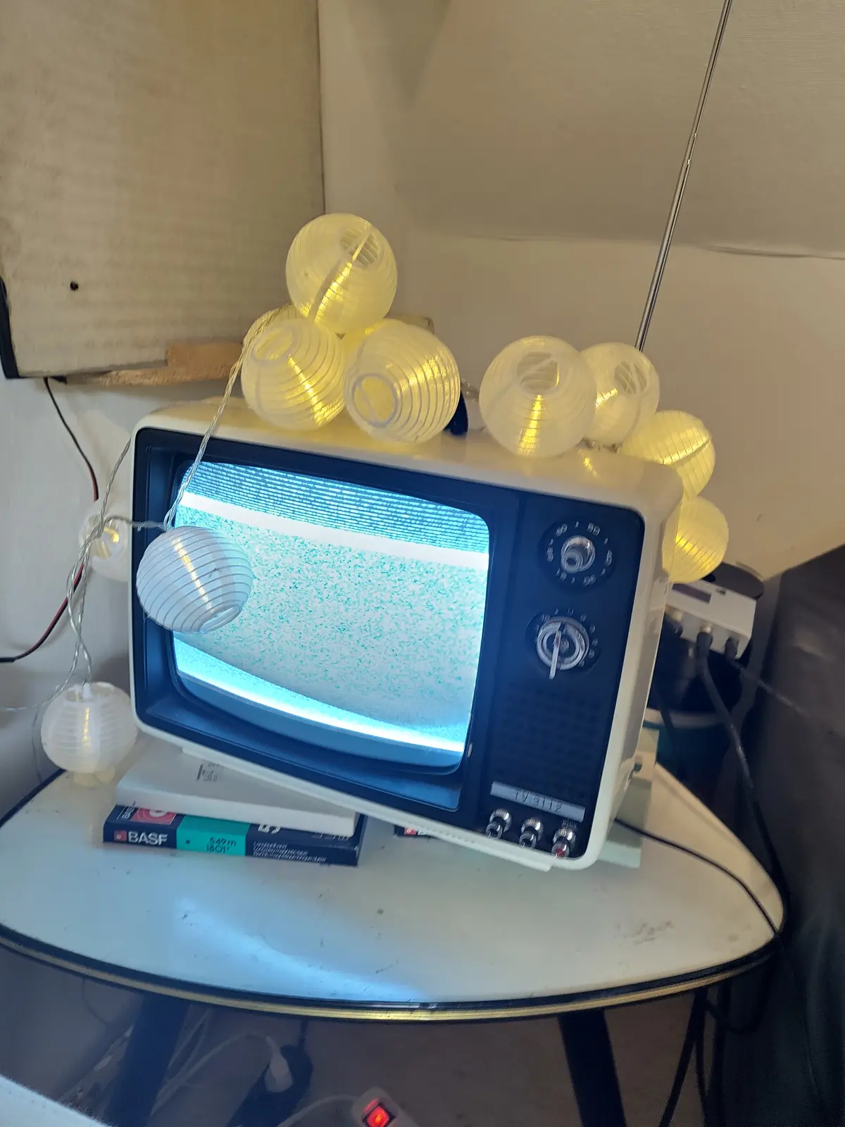 Ein alter Fernseher umringt von selbstgedruckten Lampions als Lichterkette
